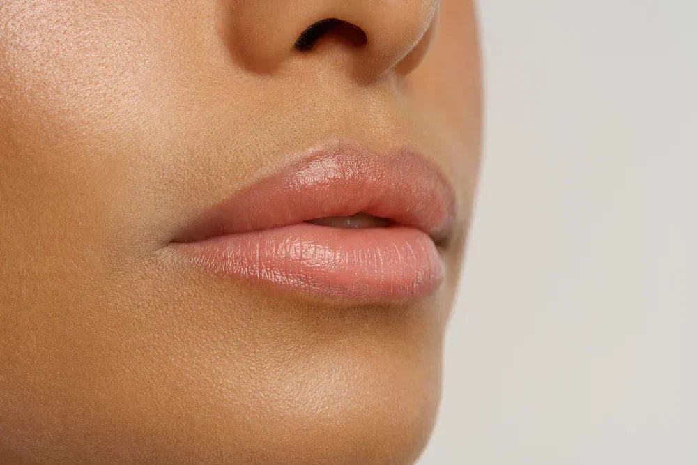 Como cuidar dos seus lábios antes e depois da micropigmentação? Imagem close-up de lábios bem hidratados e com tom neutro, destacando a beleza natural e a suavidade da pele.