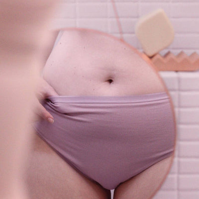 mulher com calcinha bege na frente do espelho e barrinha do lado