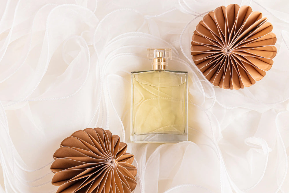 Imagem de um frasco de perfume elegante em um fundo suave, realçado por elementos decorativos em papel. Ideal para amantes de fragrâncias luxuosas.