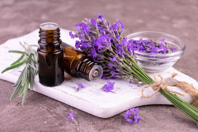 Aromaterapia com óleos essenciais de lavanda, incluindo um buquê de lavanda, frascos de vidro com óleos e uma tigela com lavanda seca, em ambiente tranquilo e natural.