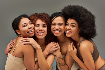 Grupo de mulheres sorrindo em harmonia, celebrando a beleza da diversidade e da amizade, com diferentes tipos de cabelo e tons de pele.