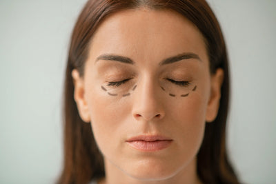 A imagem apresenta uma mulher com os olhos fechados e desenhos marcando a área dos olhos.