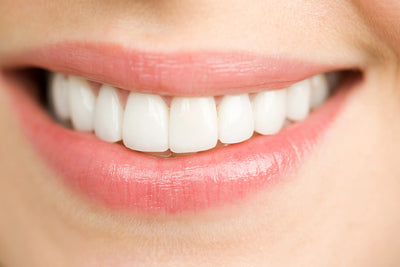 Sorriso radiante com dentes brancos e saudáveis, destacando a importância da higiene bucal e cuidados dentários para um sorriso perfeito.